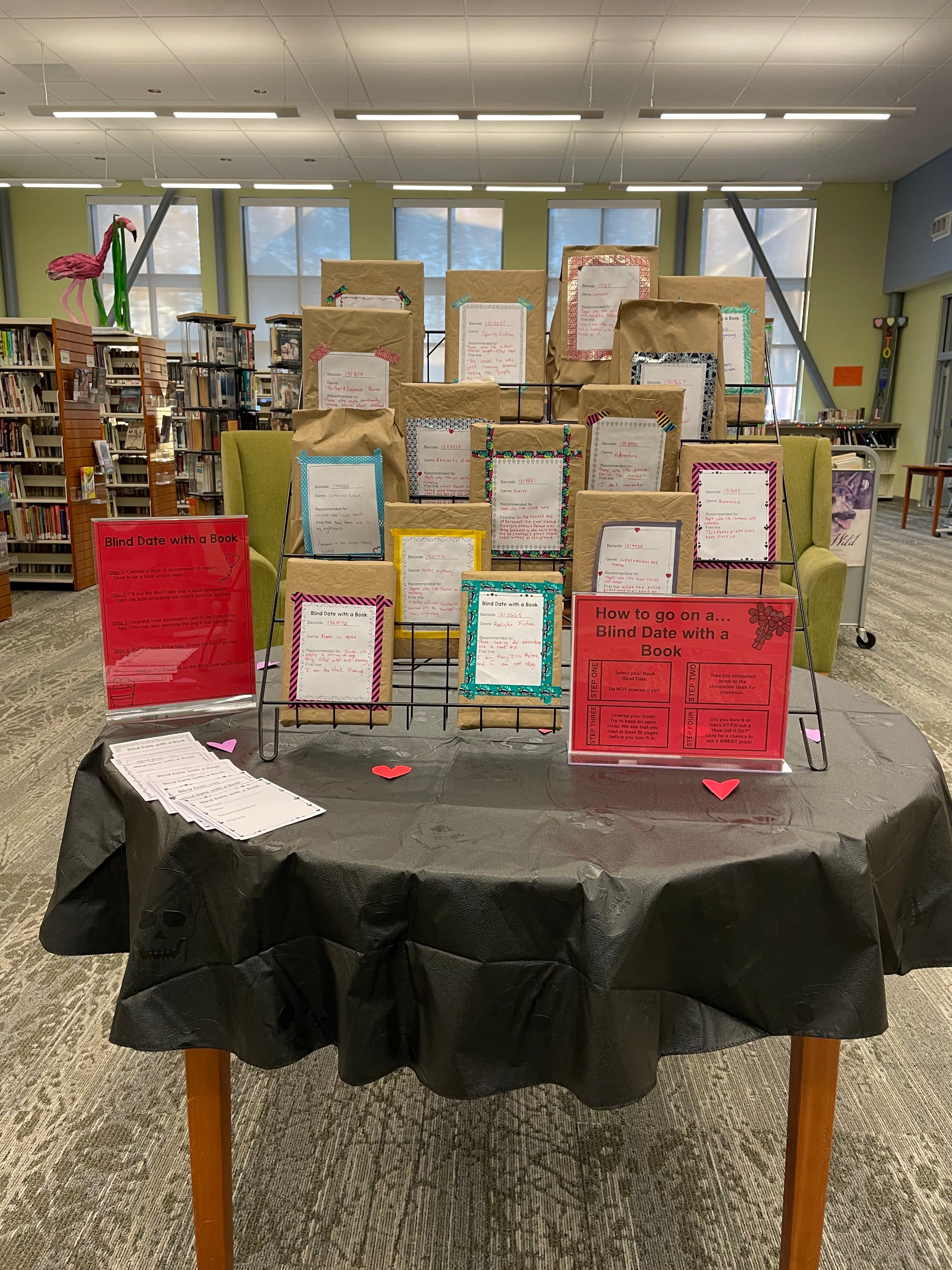 A table with a display of books wrapped in brown paper. Each book has a brief description on the paper.